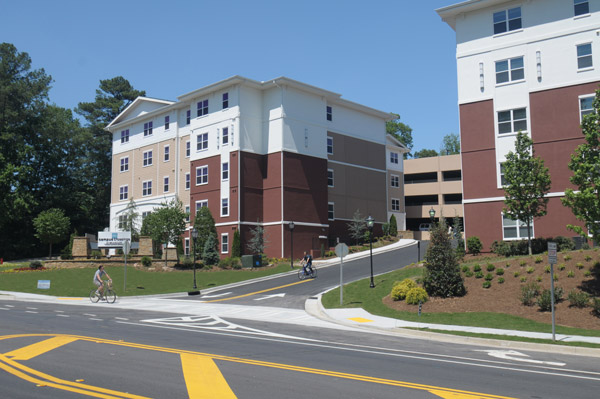 a large apartment building with a parking garage in the background