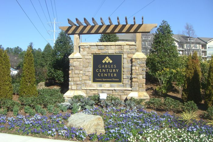 a sign for the century center is surrounded by flowers and trees