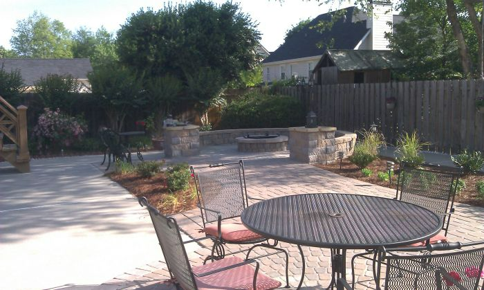a patio with a table and chairs in front of a house
