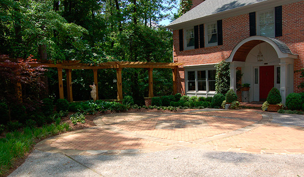 a large brick house with a large driveway in front of it .