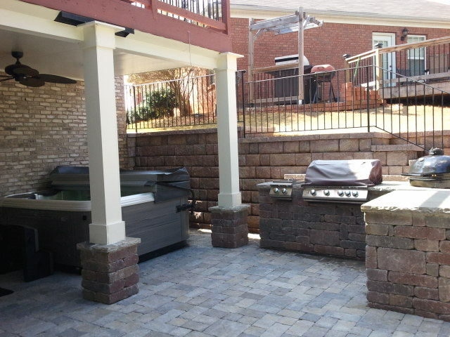 a patio with a grill and a ceiling fan