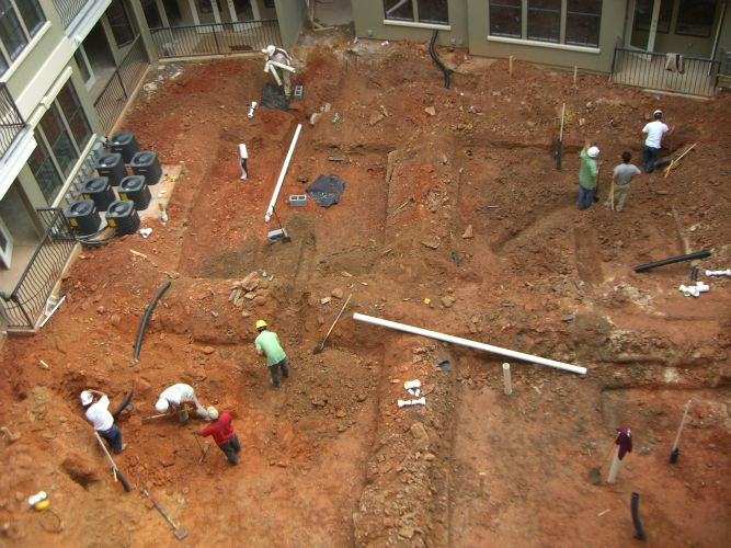 a group of construction workers are digging in the dirt .
