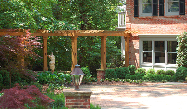 a brick house with a wooden pergola in front of it .