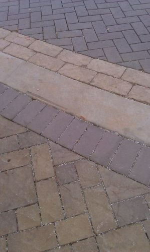 a close up of a brick walkway with different colored bricks .