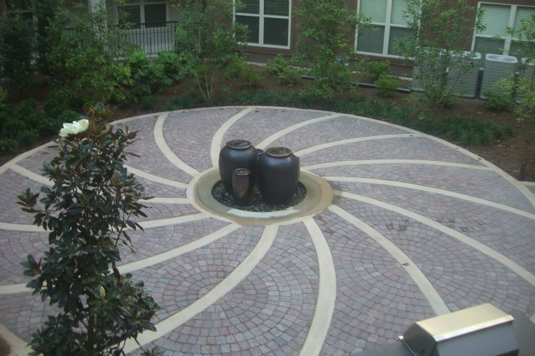 a circular patio with a fountain in the middle