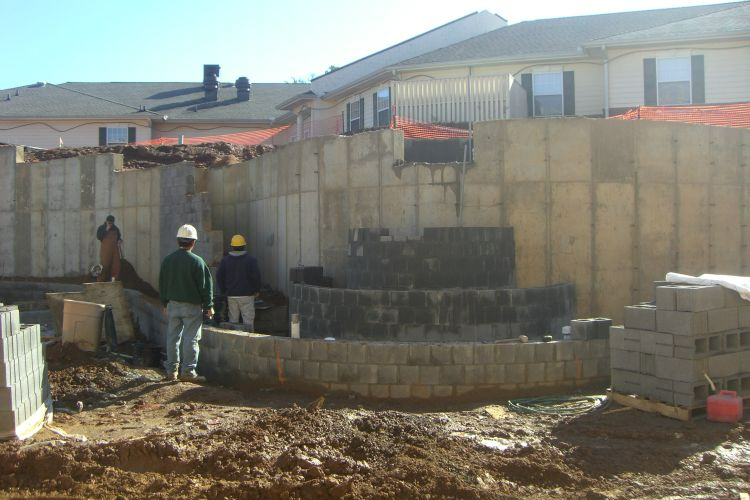 a man wearing a hard hat stands in front of a building under construction