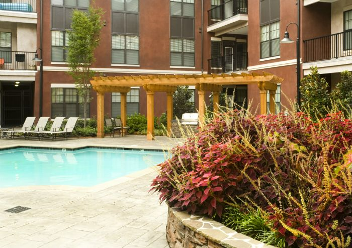 a large swimming pool in front of a brick building