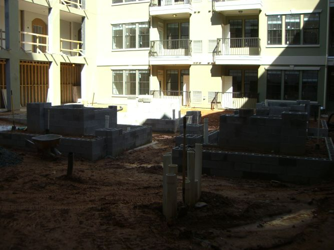 a building under construction with a lot of dirt in front of it