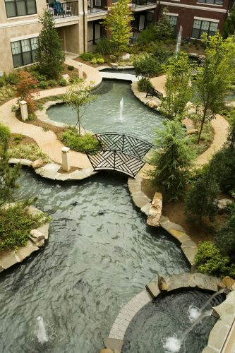 an aerial view of a pond with a bridge over it