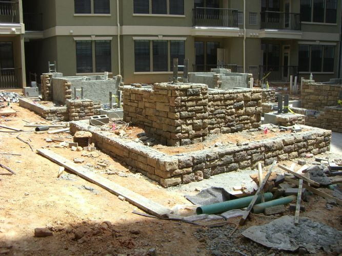 a stone wall is being built in front of a building