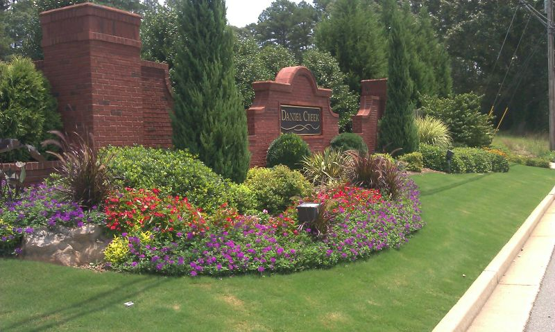 a sign that says burwell park is surrounded by flowers and trees