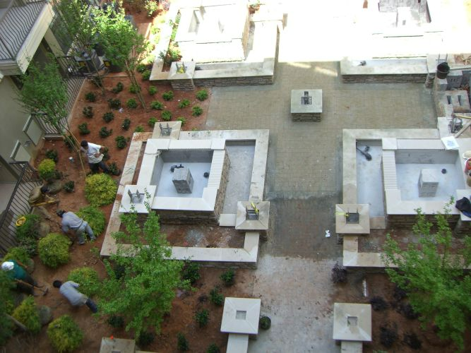 an aerial view of a garden with a fountain in the middle