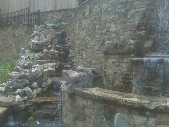 there is a waterfall in the middle of a stone wall .