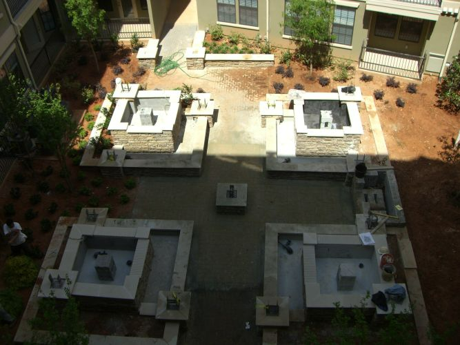 an aerial view of a courtyard with a fountain in the middle