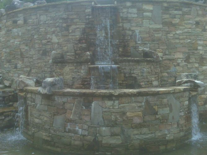 there is a waterfall in the middle of a brick wall .