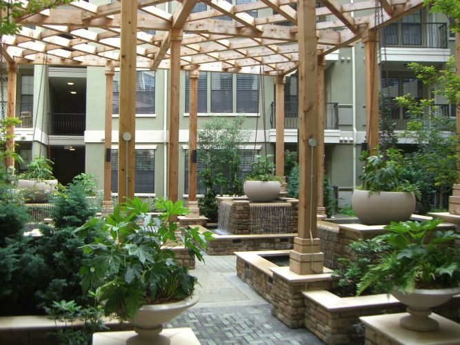 a courtyard with a pergola and potted plants