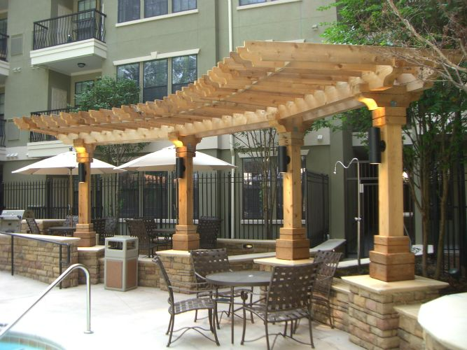 a table and chairs under a pergola next to a pool