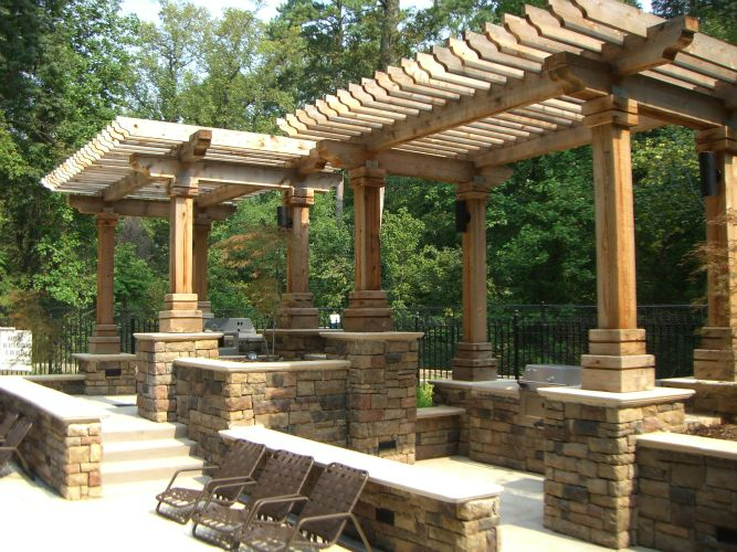 a patio area with a wooden pergola and chairs
