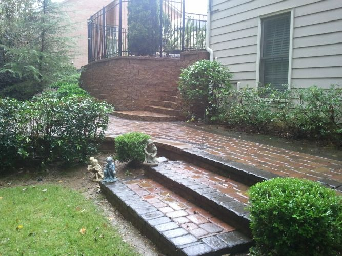 a brick walkway with stairs leading up to a house .