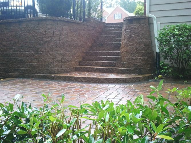 a brick walkway with stairs leading up to a house