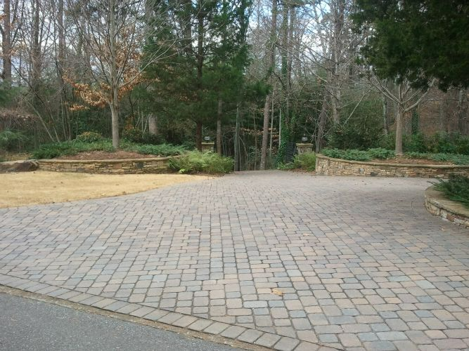 a brick driveway with trees in the background