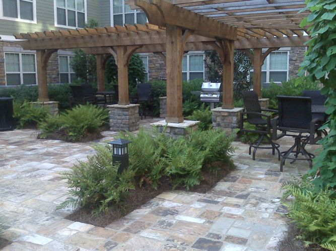 a patio with a pergola and tables and chairs