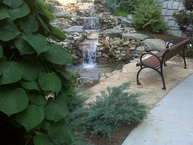 a waterfall with a bench in front of it