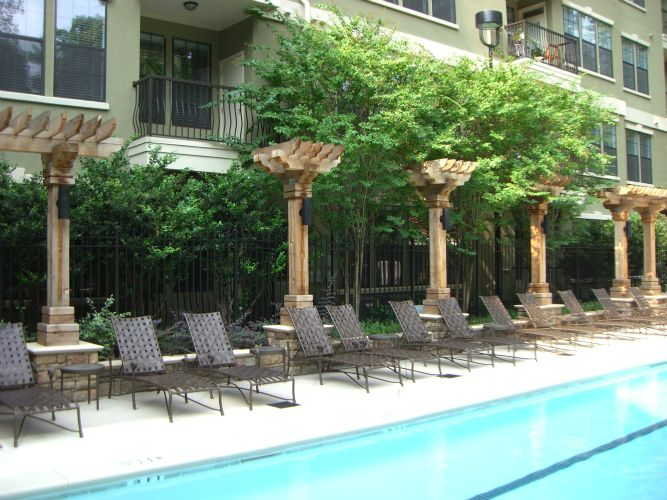 a large swimming pool surrounded by lounge chairs and pergolas
