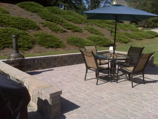 a patio with a table and chairs under an umbrella