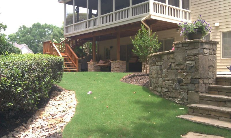 a house with a screened in porch and stairs leading to it .