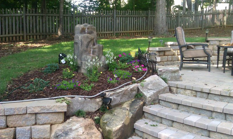 a patio with a table and chairs and a fence in the background