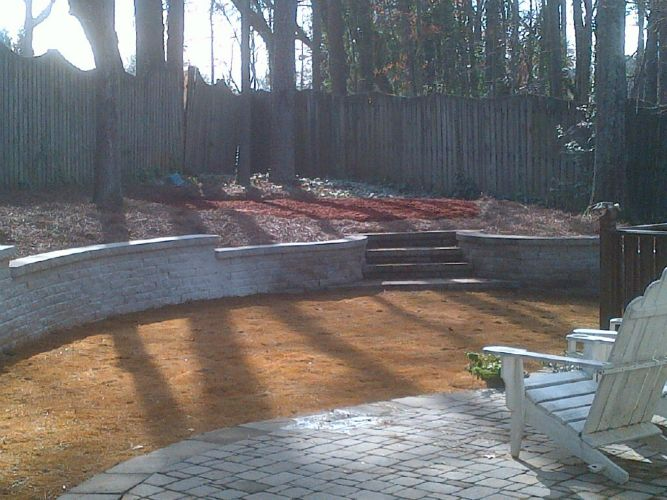 a white chair is sitting on a patio in front of a fence .