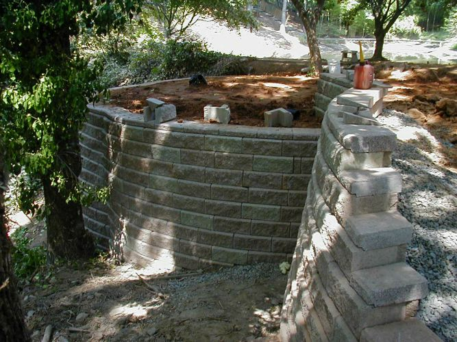 a brick wall is being built in the middle of a forest .
