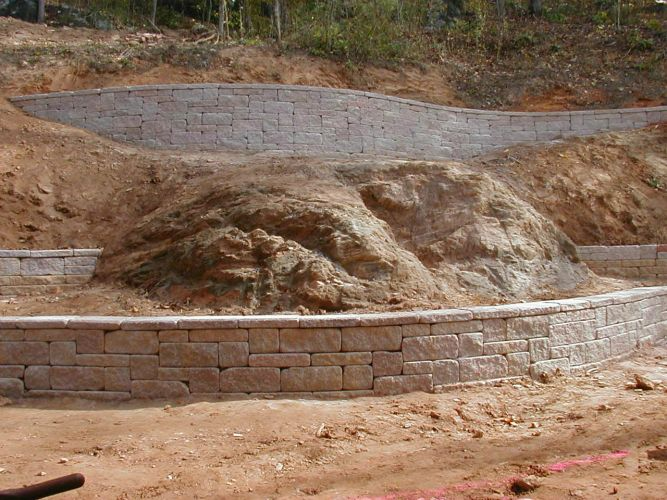 a brick wall is being built on top of a dirt hill .