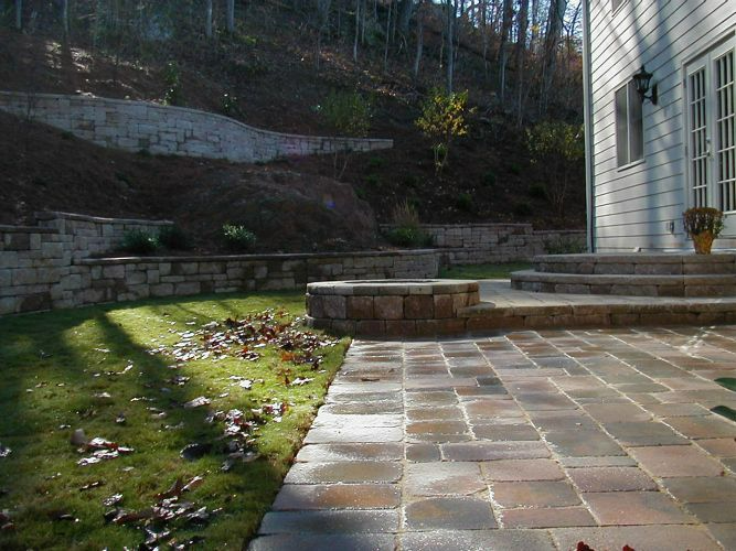 a patio with steps leading to a house in the woods .