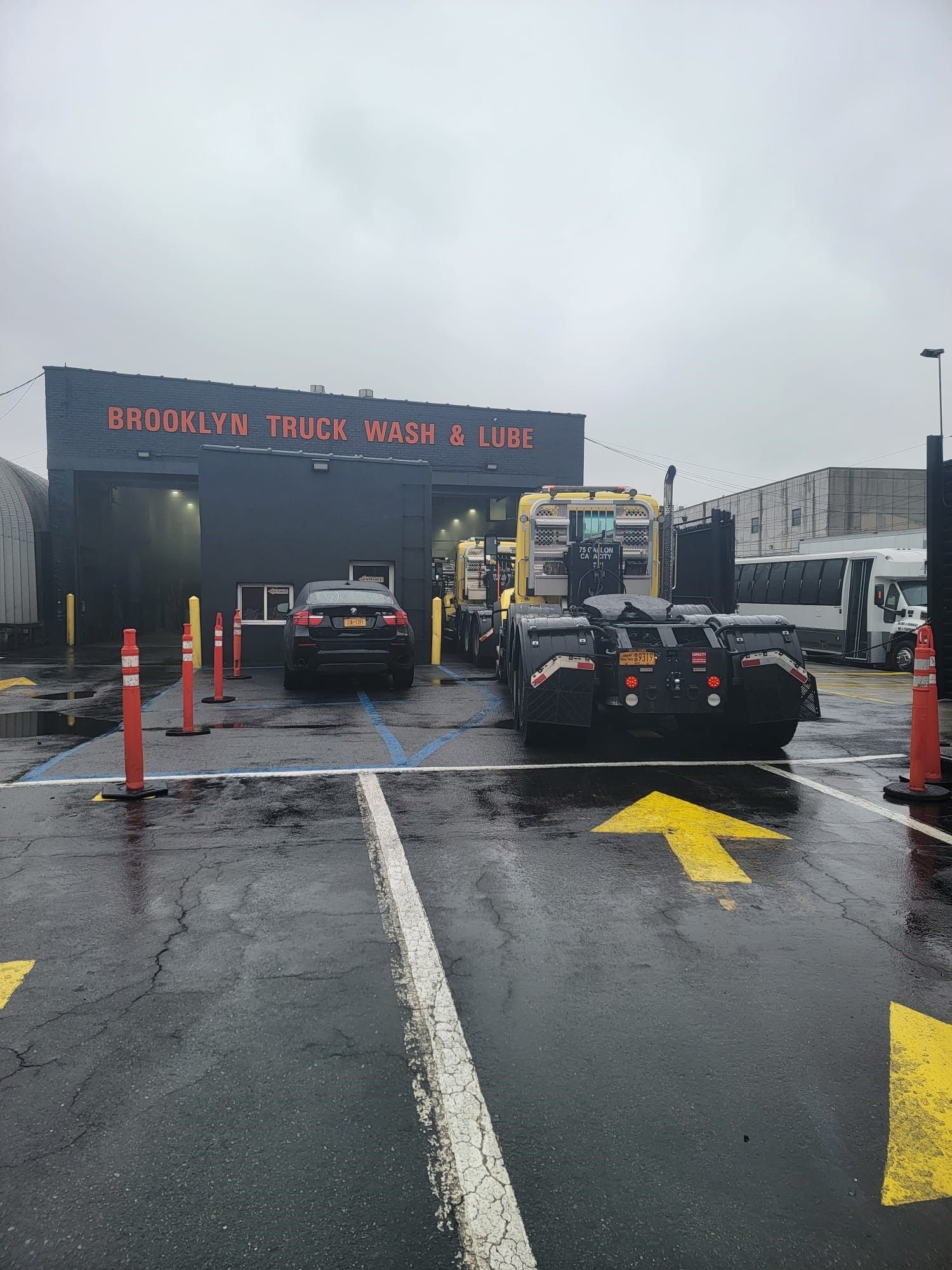 A parking lot with cars parked in front of a building that says brooklyn truck wash & lube.