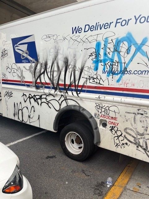 A mail truck is covered in graffiti