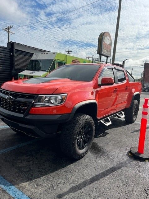 A red truck parked next to a green van