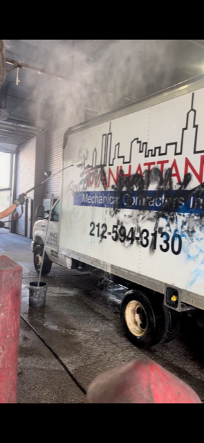 A truck is being cleaned in a garage