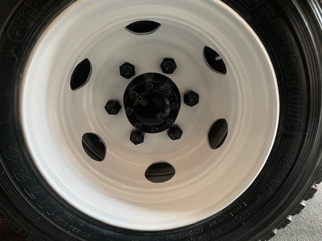 A close up of a white wheel with a black hub