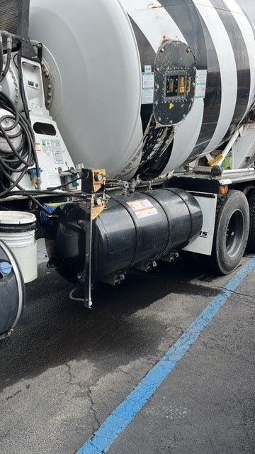 A concrete mixer truck is parked in a parking lot next to a blue line