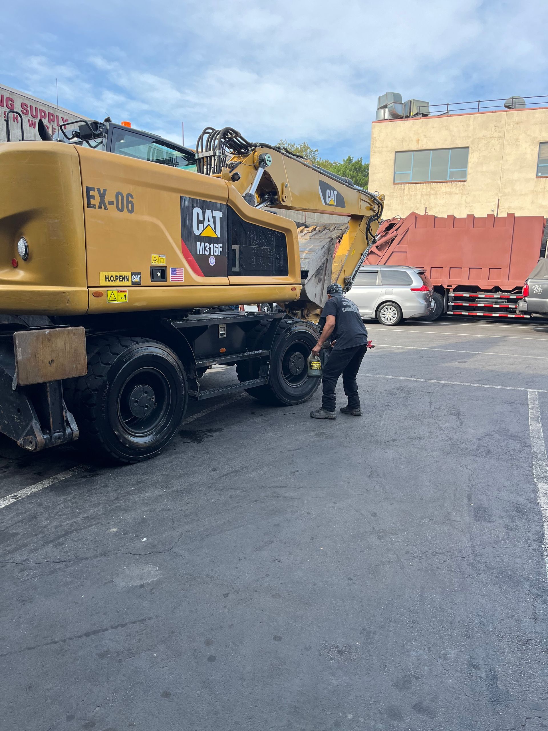 A man is cleaning a CAT excavator