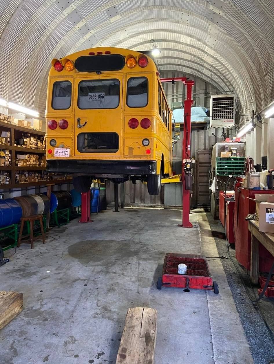 A yellow school bus is sitting on a lift
