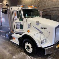 A white semi truck is parked in a garage