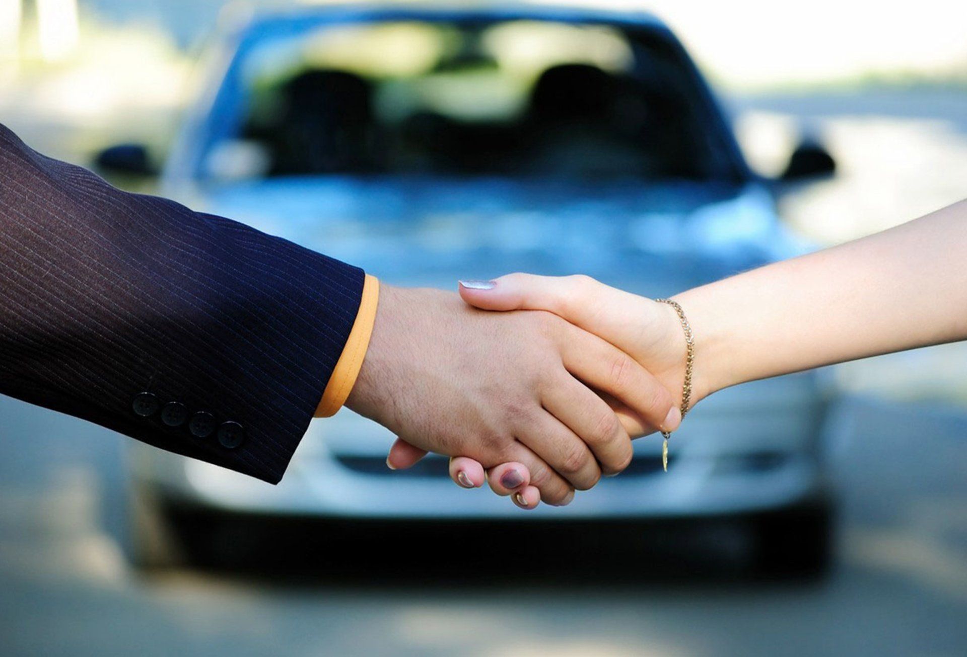 Handshake in front of a car