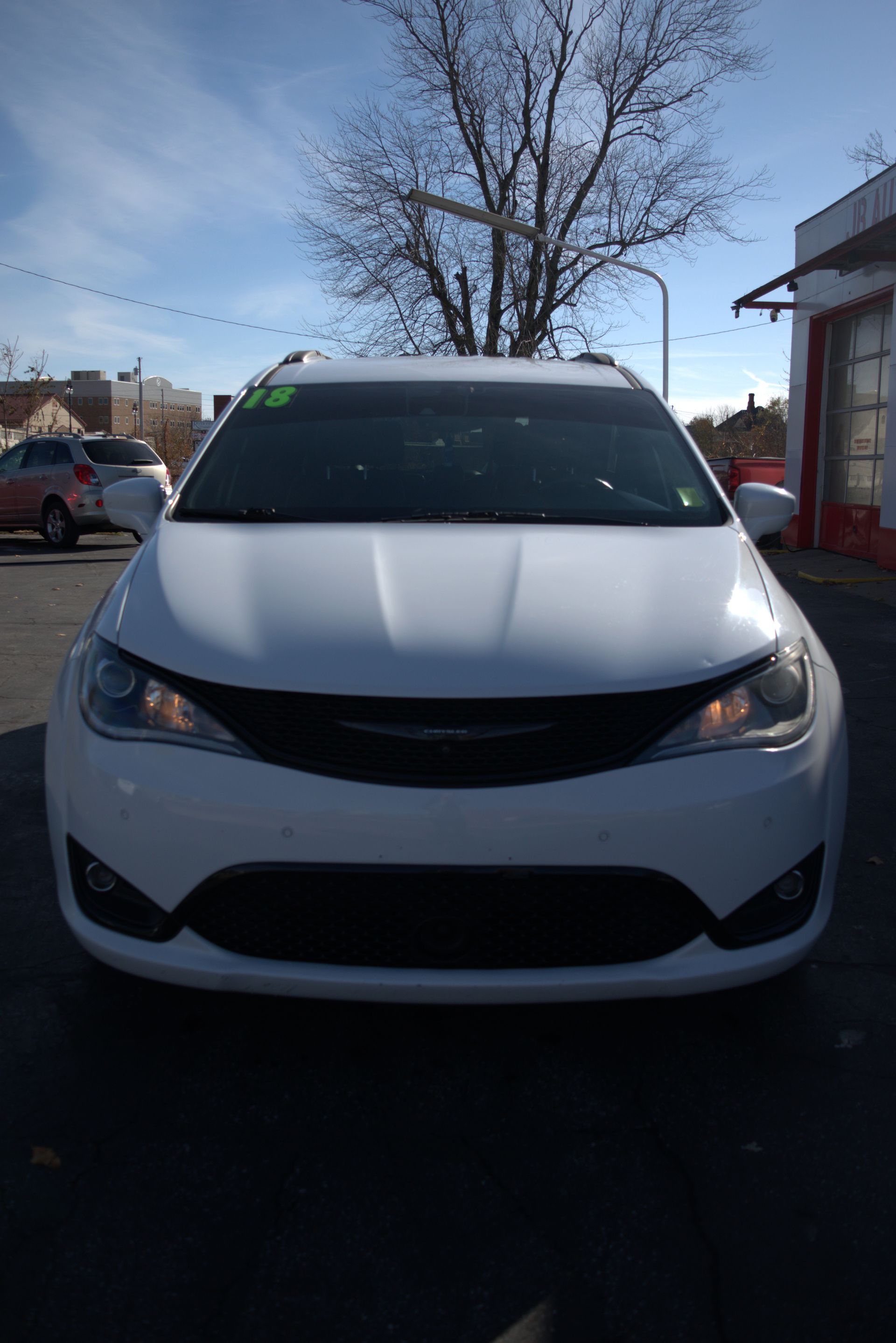 A white car is parked in a parking lot