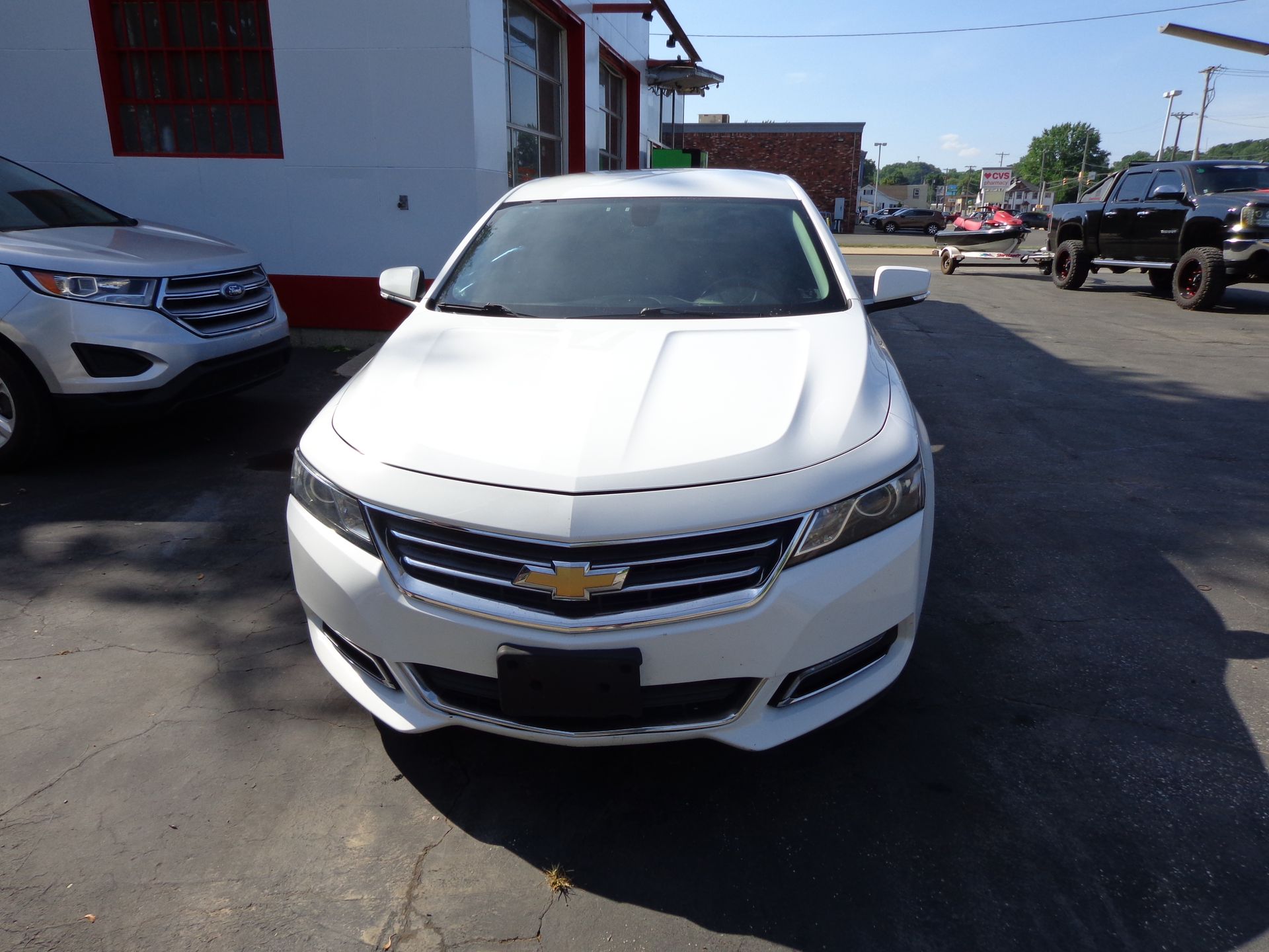 A white car is parked in a parking lot