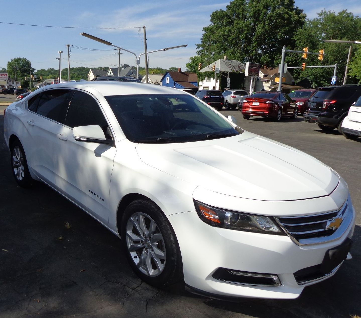 A white car is parked in a parking lot