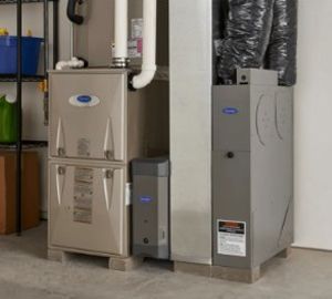 Two gray Carrier HVAC units with ductwork in a utility room.