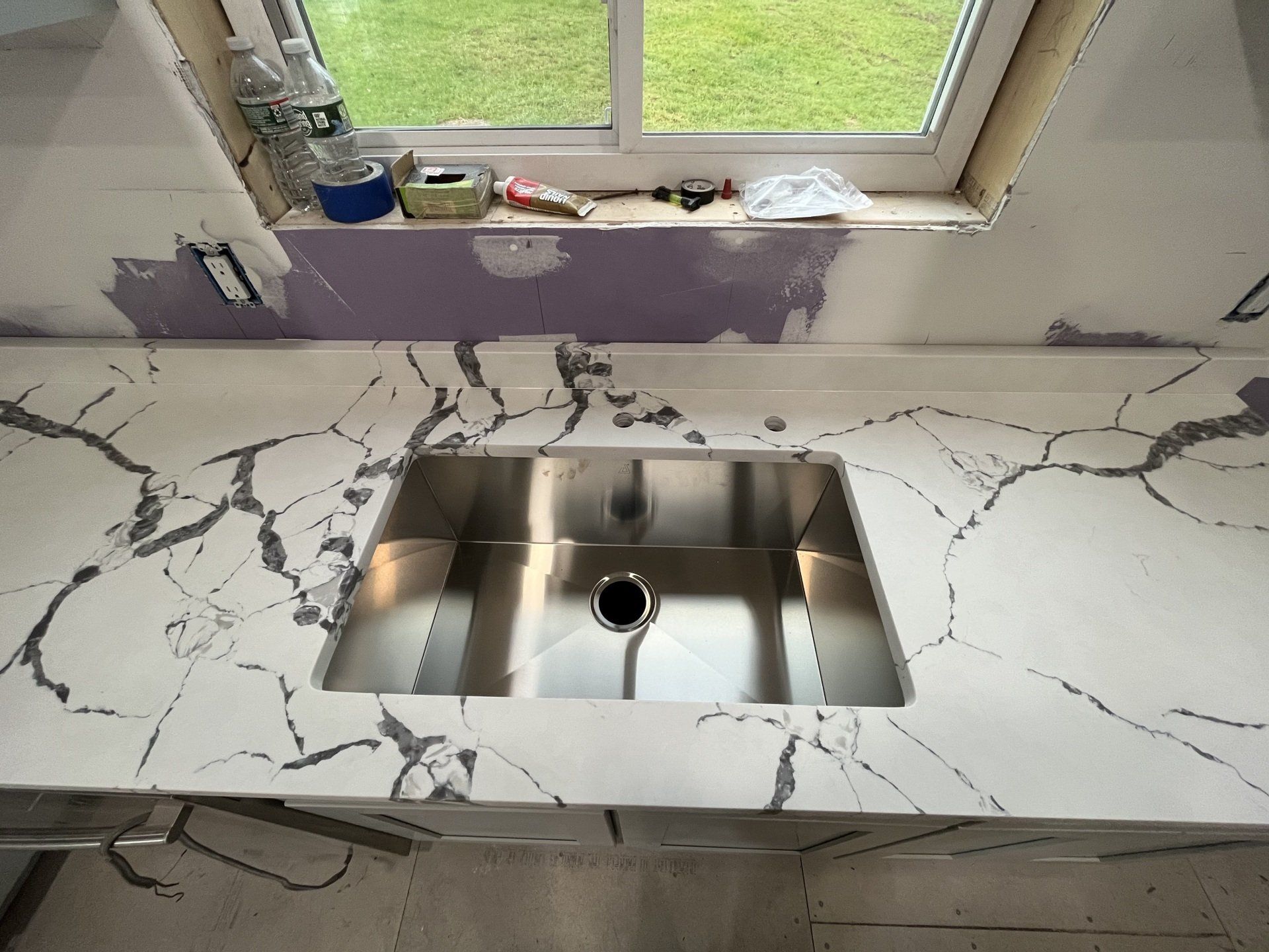 A quartz countertop with stainless steel sink
